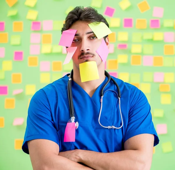 Médico joven con muchos recordatorios y trabajo urgente —  Fotos de Stock