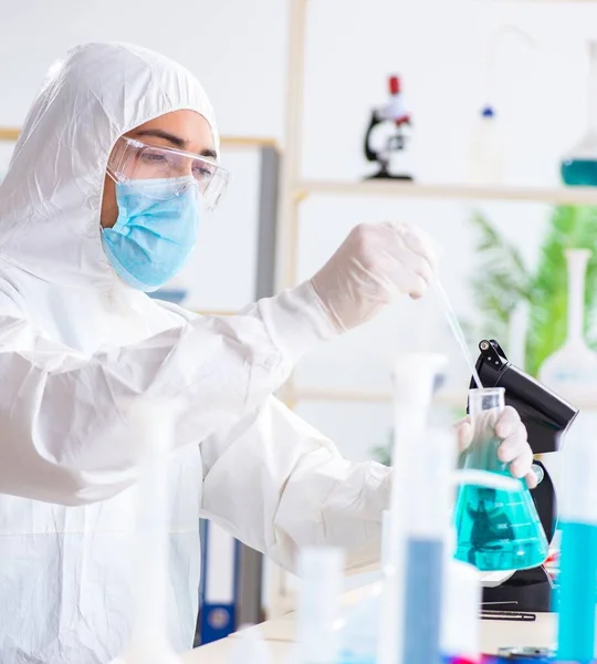 Jovem estudante de química que trabalha em laboratório em produtos químicos — Fotografia de Stock