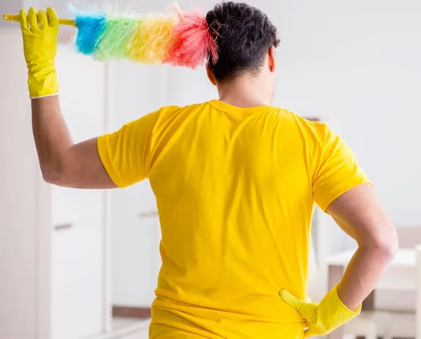 Man husband cleaning the house helping his wife — Stock Photo, Image