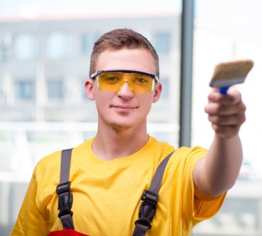 Sarı tulumlu genç inşaat işçisi.