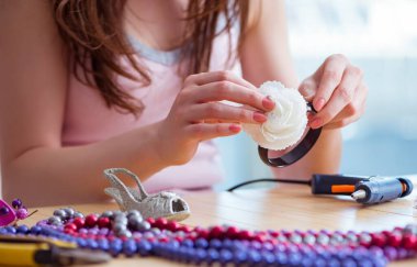 Kadın evde mücevher yapıyor.