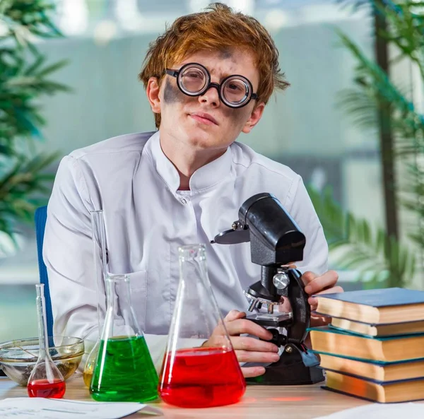 Mladý šílený chemik pracující v laboratoři — Stock fotografie