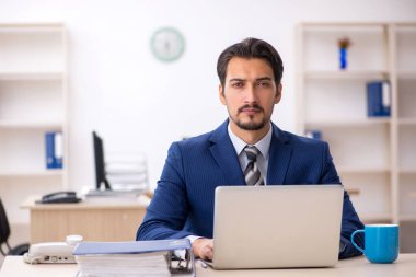 Ofiste çalışan genç bir erkek.