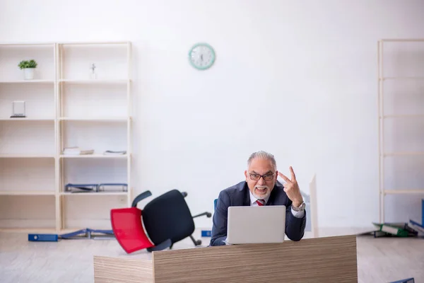 Oude mannelijke werknemer die overuren maakt op kantoor — Stockfoto