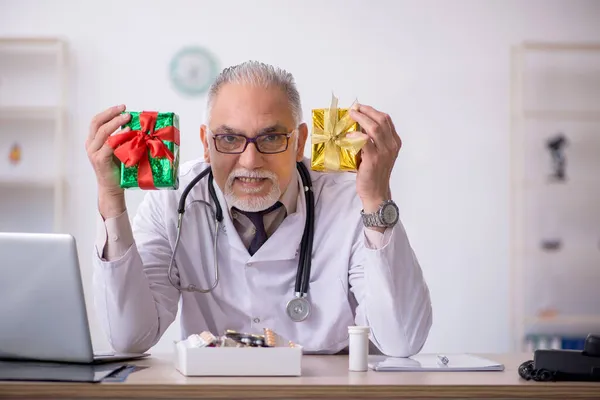 Stary lekarz świętuje Boże Narodzenie w szpitalu. — Zdjęcie stockowe