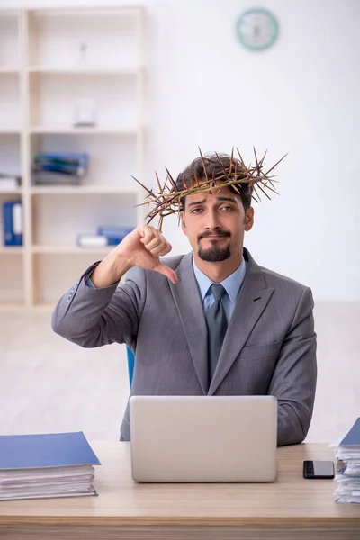 Junge männliche Angestellte trägt stacheligen Kranz auf dem Kopf — Stockfoto