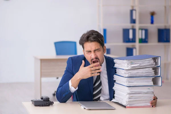 Jonge mannelijke werknemer en te veel werk op kantoor — Stockfoto