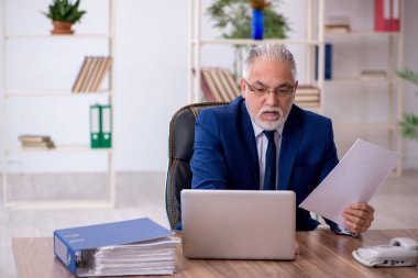 Ofiste çalışan yaşlı bir erkek.