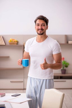 Genç erkek çalışan salgın sırasında evden çalışıyor.