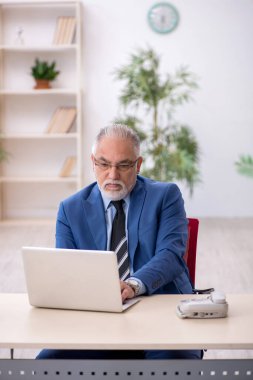 İş yerinde çalışan yaşlı bir işadamı