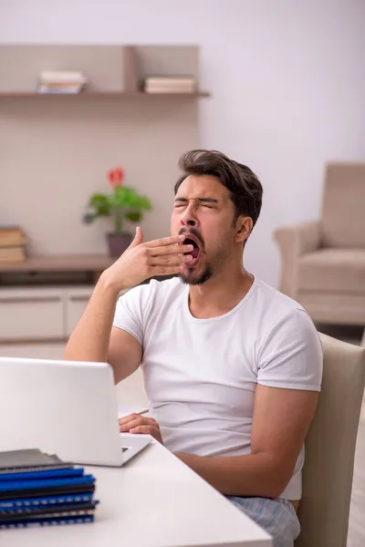 Ung manlig anställd som arbetar hemifrån under en pandemi — Stockfoto