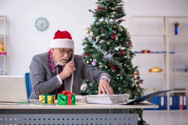 У віці чоловік працівник святкує Різдво на робочому місці — стокове фото
