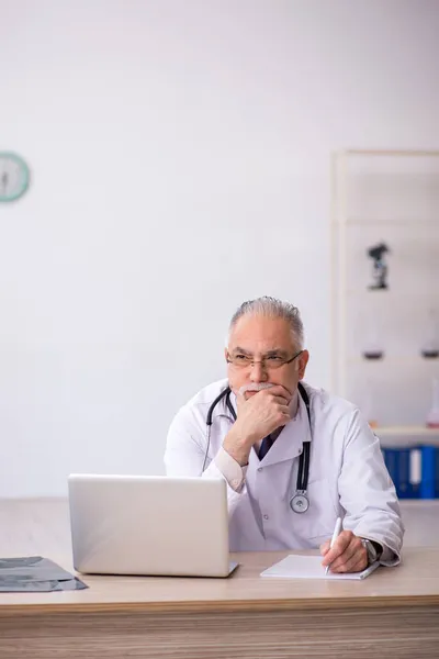 Gammal manlig läkare som arbetar på sjukhuset — Stockfoto