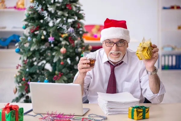 Funcionário idoso do sexo masculino comemorando o Natal no local de trabalho — Fotografia de Stock