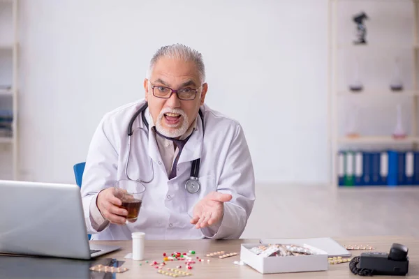 Velho médico do sexo masculino que trabalha no hospital — Fotografia de Stock