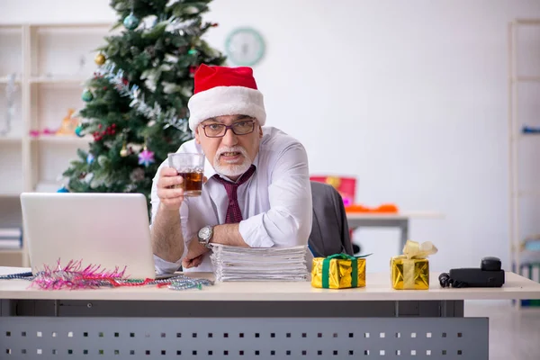 Věk muž zaměstnanec slaví Vánoce na pracovišti — Stock fotografie