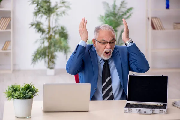 Viejo empleado masculino y caja de dinero vacío en el lugar de trabajo — Foto de Stock