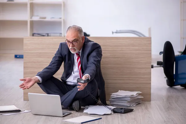 Old male employee working overtime in the office — Stock Photo, Image