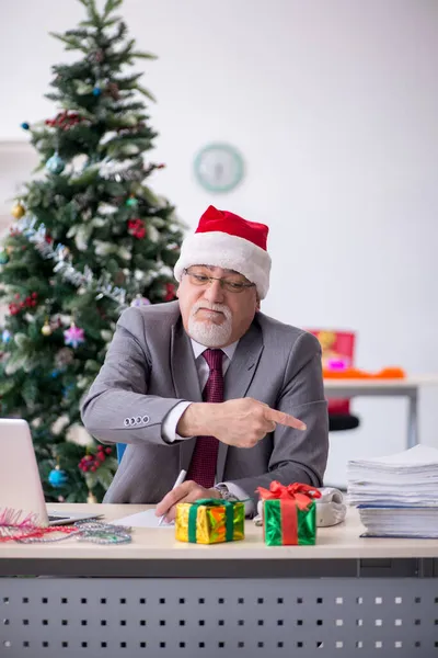 Alderen mandlige medarbejder fejrer jul på arbejdspladsen - Stock-foto