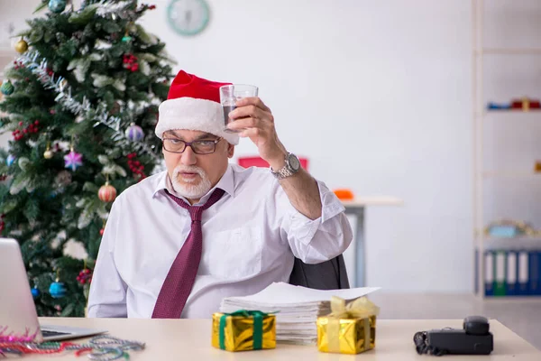 Verouderde mannelijke werknemer viert Kerstmis op het werk — Stockfoto