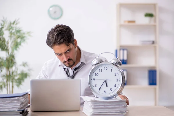 Joven empleado masculino en concepto de gestión del tiempo —  Fotos de Stock