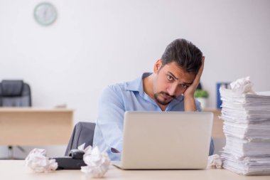 Genç bir erkek çalışan ofiste yeni fikirleri reddediyor.