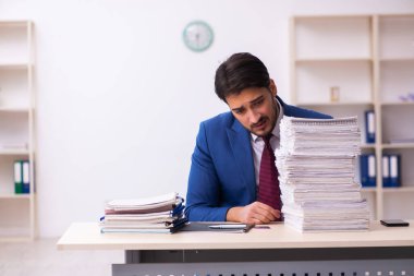 Genç işadamı ve ofiste çok fazla iş var.