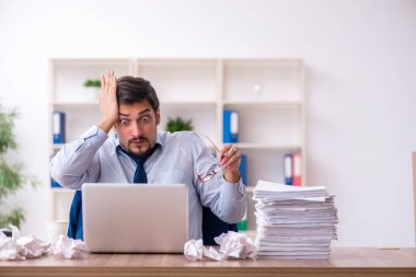 Genç bir erkek çalışan ofiste yeni fikirleri reddediyor.