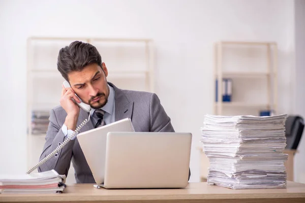 Joven empleado masculino descontento con el trabajo excesivo en la oficina — Foto de Stock