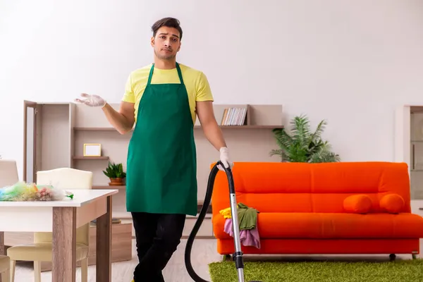 Joven contratista masculino limpiando la casa en interiores —  Fotos de Stock