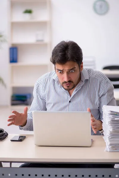 Junge männliche Mitarbeiter und zu viel Arbeit im Büro — Stockfoto