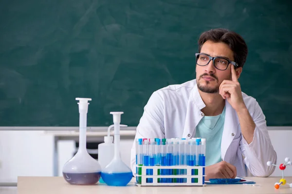 Jonge mannelijke chemicus voor schoolbord — Stockfoto