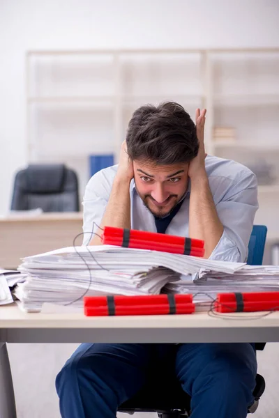 Young male employee unhappy with excessive work in the office Royalty Free Stock Images