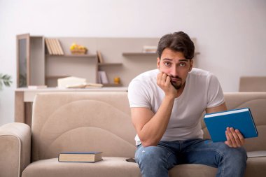 Genç erkek öğrenci salgın sırasında evde çalışıyor.