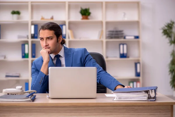 Jeune employé masculin assis dans le bureau — Photo