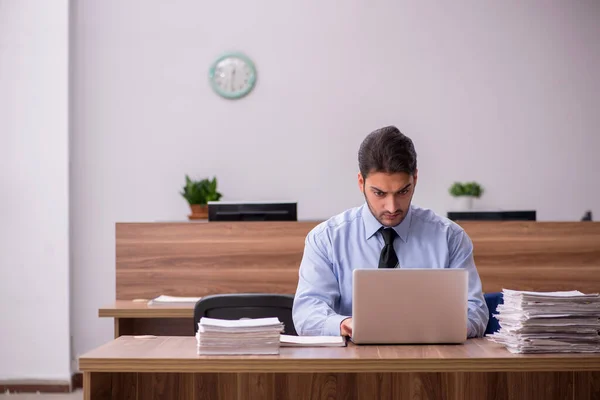 Jeune employé masculin et trop de travail au bureau — Photo