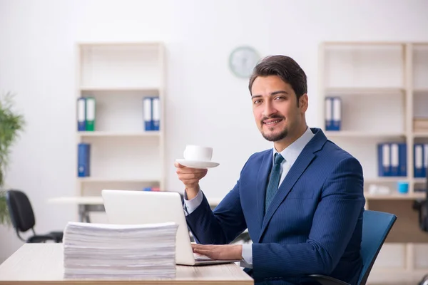 Ung manlig anställd dricker kaffe under rasten — Stockfoto