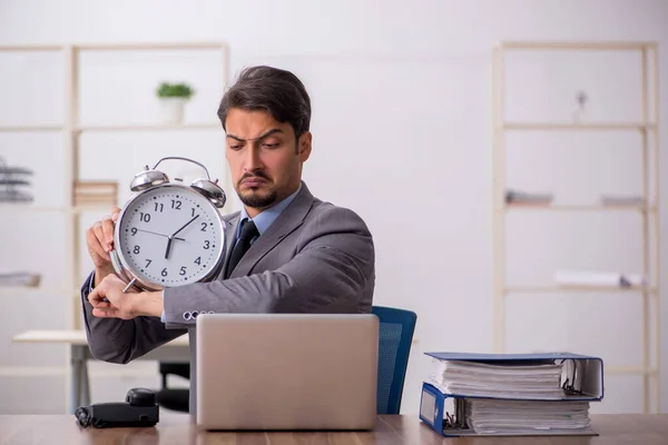 Joven empleado masculino en concepto de gestión del tiempo —  Fotos de Stock