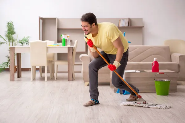 Joven contratista masculino limpiando la casa — Foto de Stock