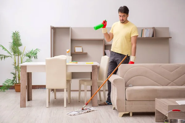 Jonge mannelijke aannemer schoonmaken van het huis — Stockfoto