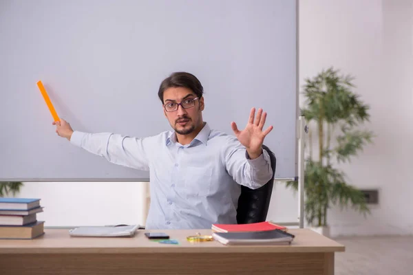 Young male teacher in front of whiteboard — Stock Photo, Image