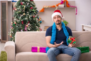Genç adam Noel 'i evde kutluyor.