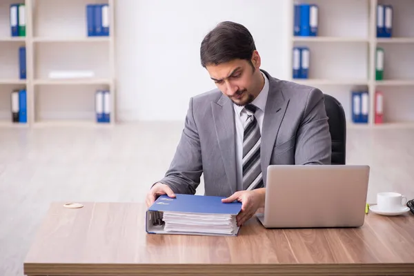 Jovem atraente masculino empregado sentado no local de trabalho — Fotografia de Stock