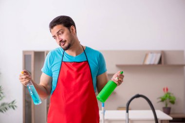 Genç erkek müteahhit evi temizliyor.