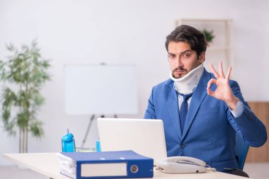 İş yerinde otururken geçirdiği kazadan sonra genç bir erkek.