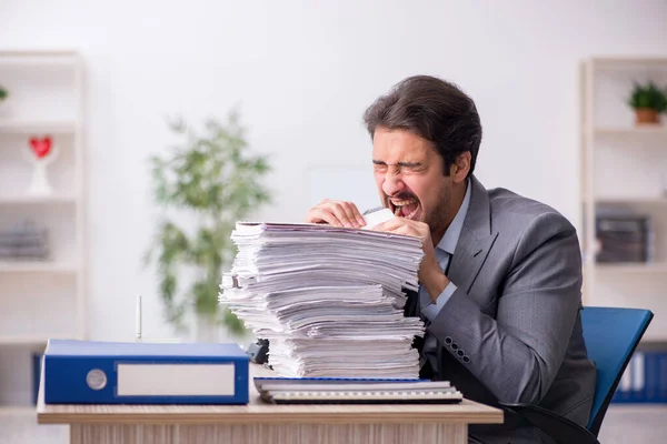 Junge männliche Mitarbeiter und zu viel Arbeit im Büro — Stockfoto