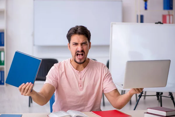 Joven estudiante masculino preparándose para los exámenes en el aula —  Fotos de Stock