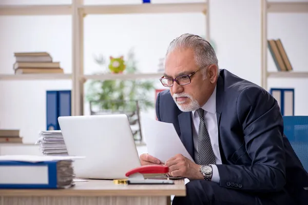 Velho empregado masculino e muito trabalho no escritório — Fotografia de Stock