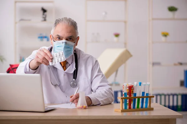 Alter Arzt arbeitet während Pandemie in der Klinik — Stockfoto