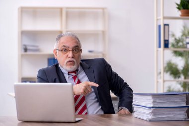 Ofiste çalışan yaşlı bir erkek.